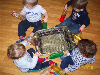 Bambini con bottiglie sul pavimento